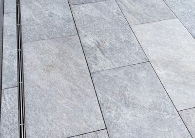 Commercial masonry construction project, small modern stone patio of an office building with patio drains.