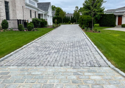 Modern residential block paving driveway renovation with block border and decorative entrance pattern and band detail.