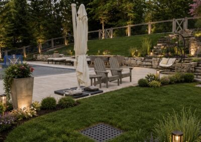 Wide-angle view of a custom stone pool patio featuring matching stone steps and multiple integrated stone retaining walls.
