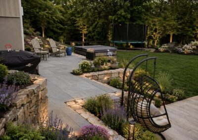 Close-up view of a premium back paver deck showing detailed stone patterns and multi-level structural stone retaining walls.