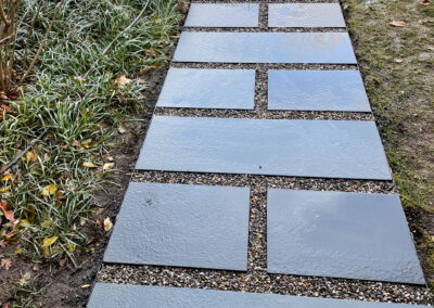 Modern minimalist walkway renovation featuring gravel path with stone stepping paver.